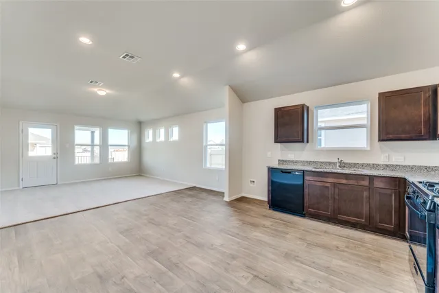a large kitchen with stainless steel appliances granite countertop a sink and a stove top oven