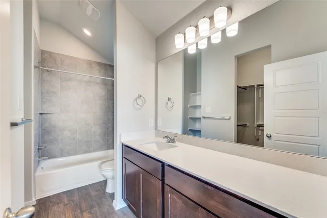 a bathroom with a bathtub shower sink and mirror