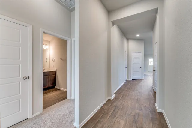 a view of a hallway with wooden floor and closet