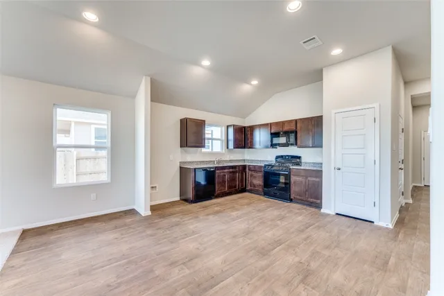 a large kitchen with stainless steel appliances granite countertop a large counter top and a stove