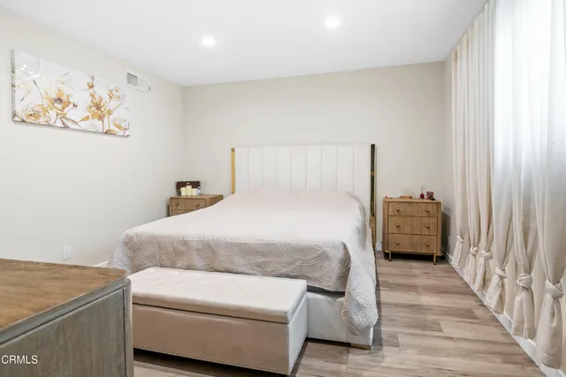 a bedroom with a bed and a painting on the wall