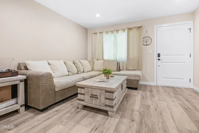 a living room with furniture and a wooden floor