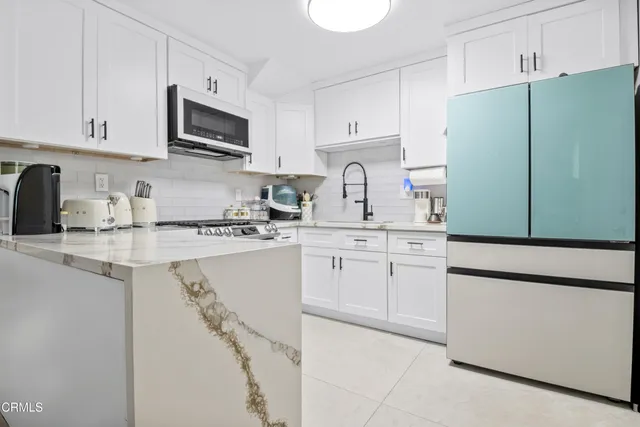 a kitchen with cabinets and a refrigerator