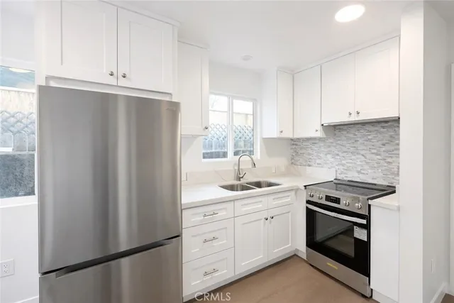 a kitchen with stainless steel appliances white cabinets and a refrigerator