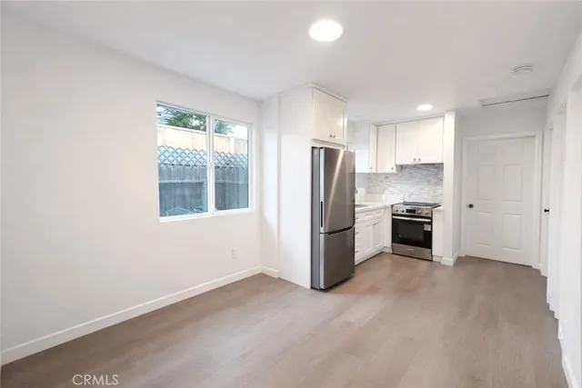 a kitchen with a refrigerator a stove top oven and a window