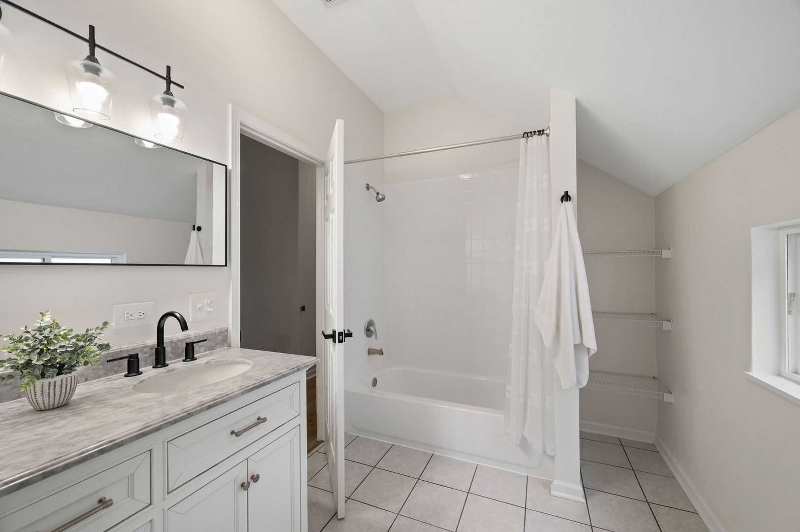 3343 West Potomac Avenue Chicago, IL 60651 - Photo 28 of 44 a bathroom with a granite countertop sink a mirror a vanity and a shower