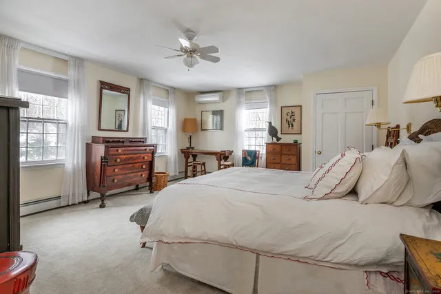 a bedroom with a bed dresser and wooden floor