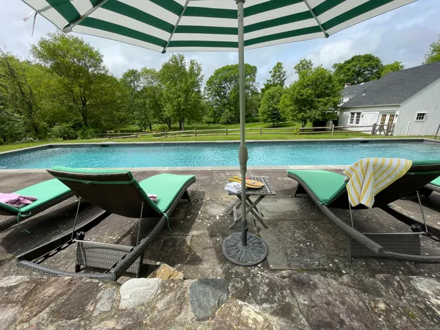 a view of a swimming pool with a patio and a yard