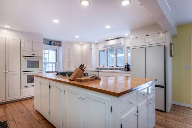 a kitchen with stainless steel appliances granite countertop a sink refrigerator and cabinets