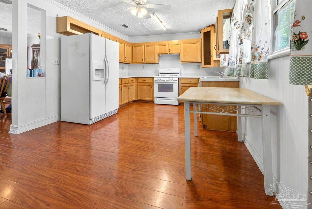 6253 Allentown Road Milton, FL 32570 - Photo 3 of 31 a kitchen with stainless steel appliances granite countertop a refrigerator a stove and a wooden floors