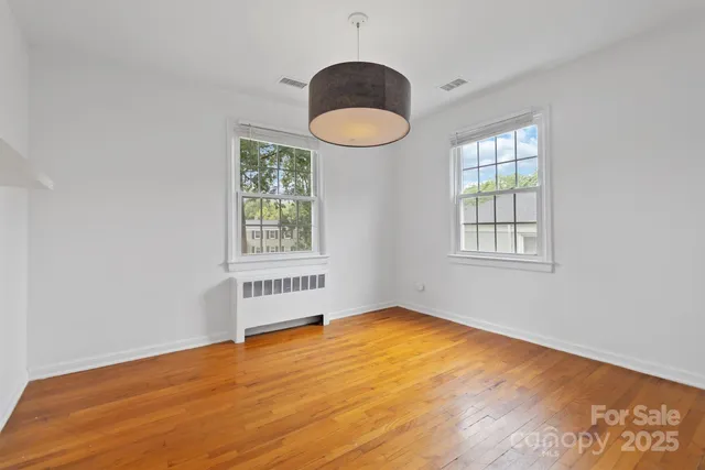 an empty room with a window and wooden floor