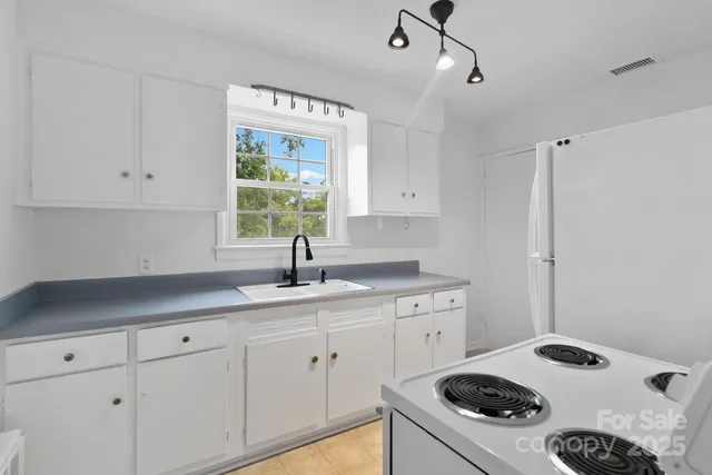 a kitchen with a sink stove and white cabinets