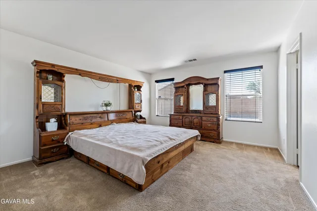a bedroom with a large bed and large window