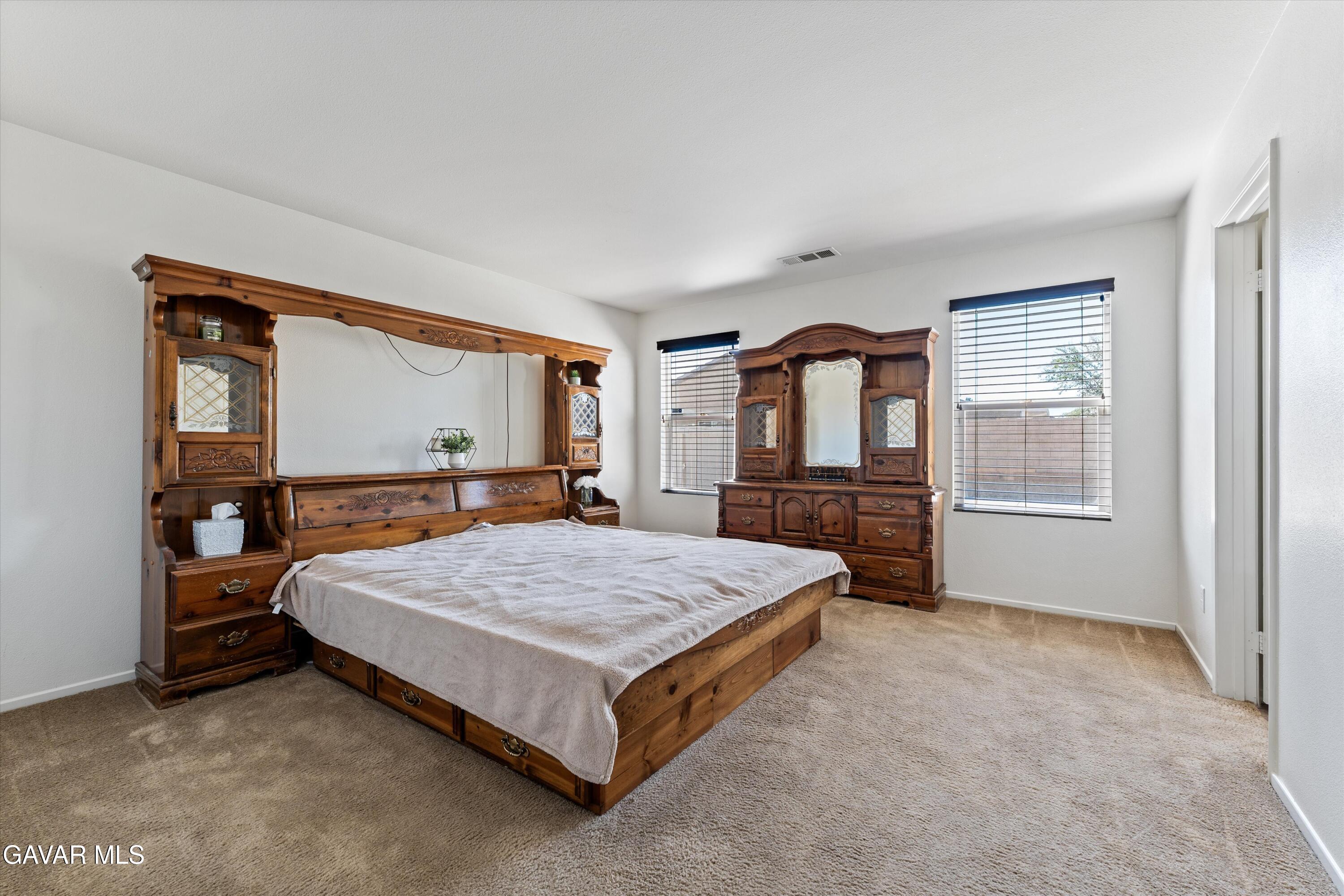 1754 West Milling Street Lancaster, CA 93534 - Photo 12 of 24 a bedroom with a large bed and large window