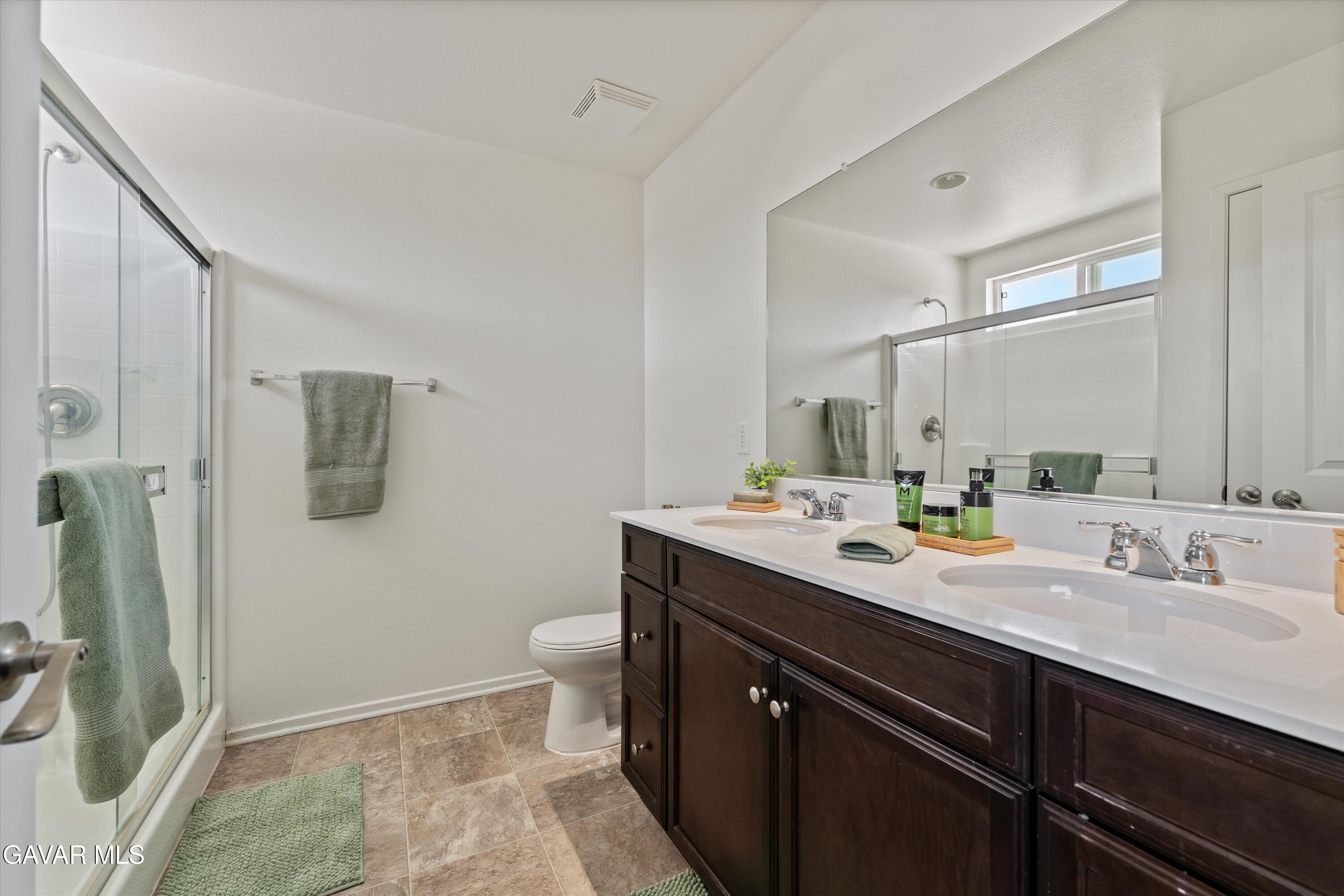 1754 West Milling Street Lancaster, CA 93534 - Photo 14 of 24 a bathroom with a sink a toilet a mirror and shower