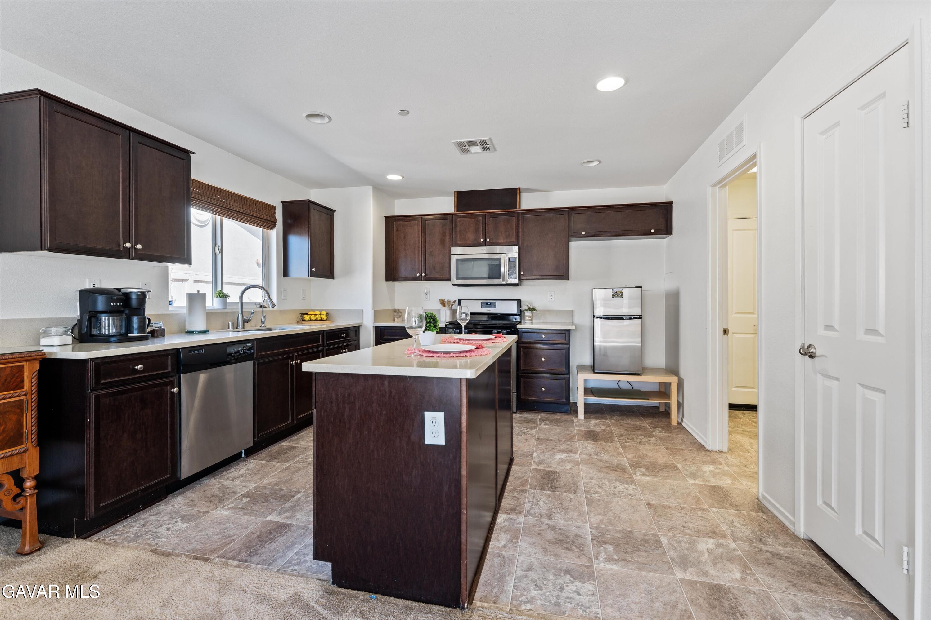 1754 West Milling Street Lancaster, CA 93534 - Photo 6 of 24 a kitchen with a sink a counter top space and cabinets