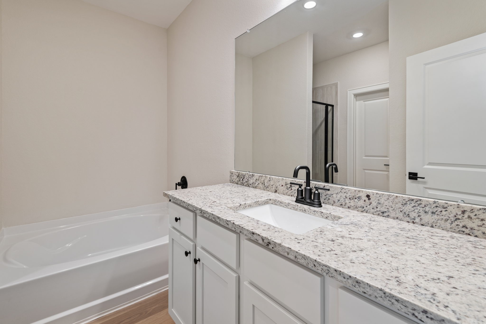 1027 Rosewood Trail Beasley, TX 77417 - Photo 15 of 22 a bathroom with a granite countertop sink and a bathtub