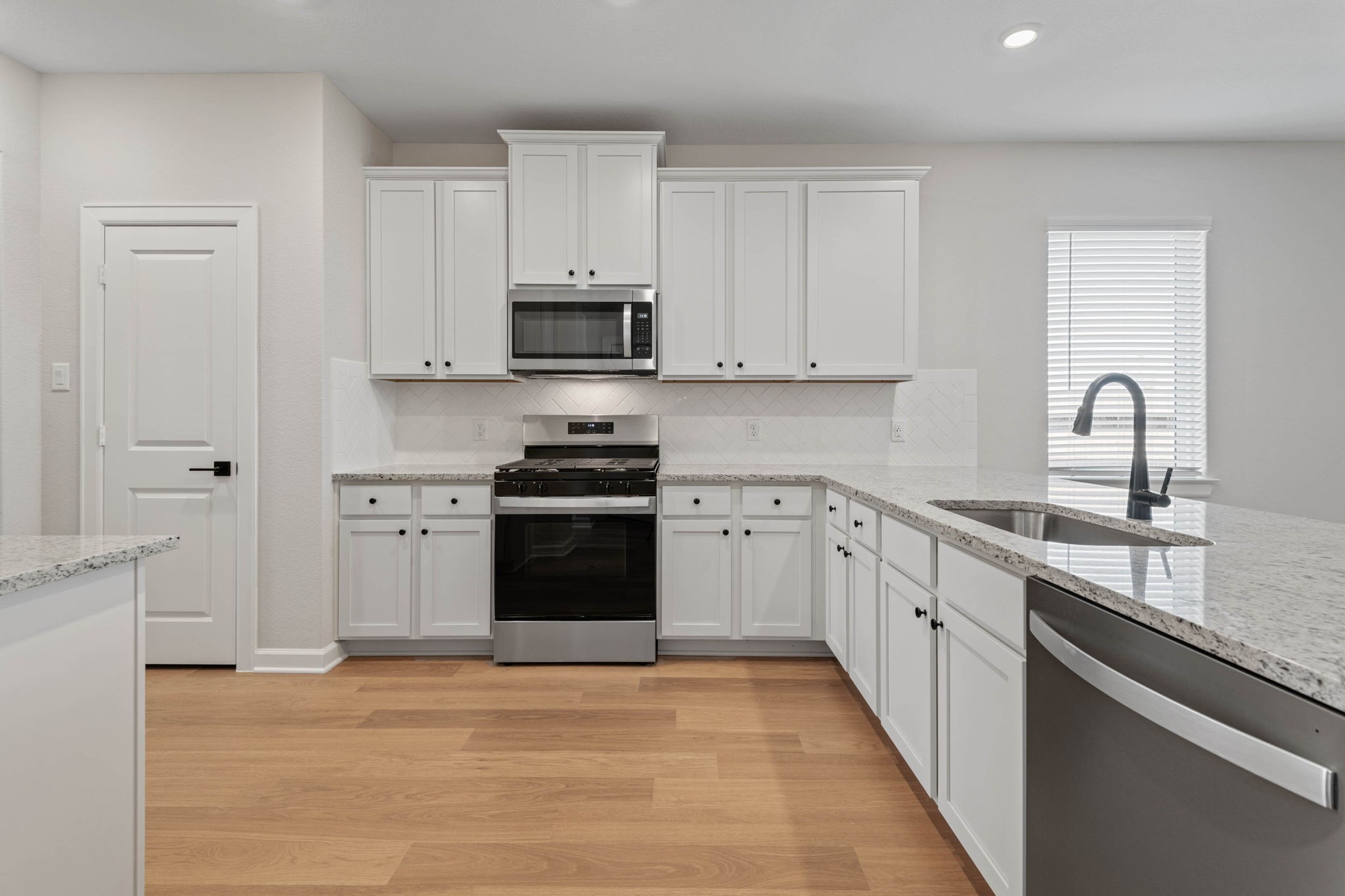 1027 Rosewood Trail Beasley, TX 77417 - Photo 6 of 22 a kitchen with white cabinets stainless steel appliances and sink