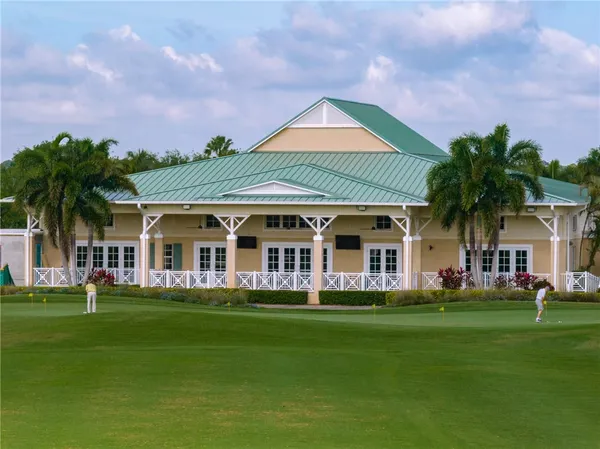 a front view of a house with a garden and trees