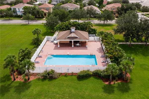 an aerial view of a house with swimming pool a yard and lake view