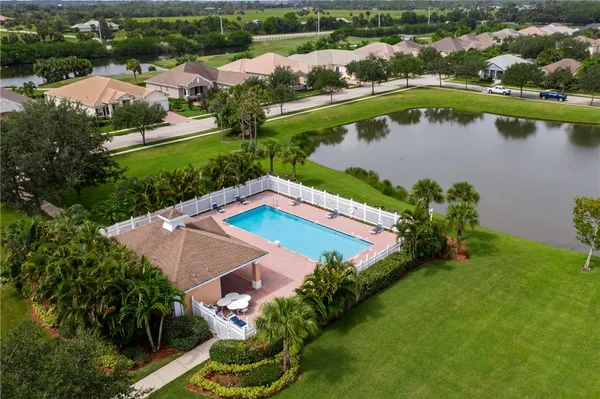 an aerial view of a house with a garden and lake view