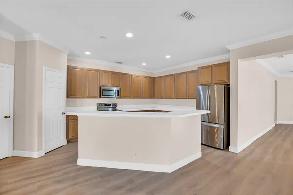 a view of kitchen with stainless steel appliances refrigerator stove microwave and cabinets