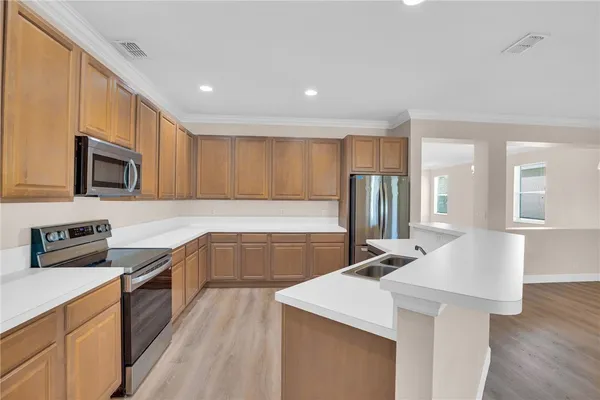 a kitchen with stainless steel appliances a sink stove and refrigerator