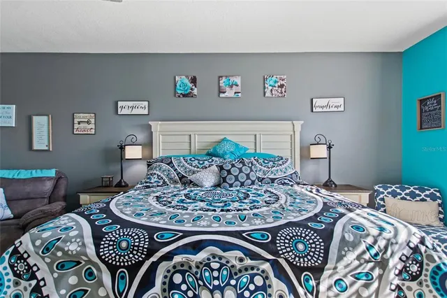 a bed sitting in a bedroom next to a lamp with a rug