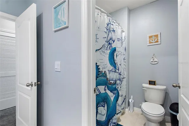 a white toilet sitting next to a bathroom and shower