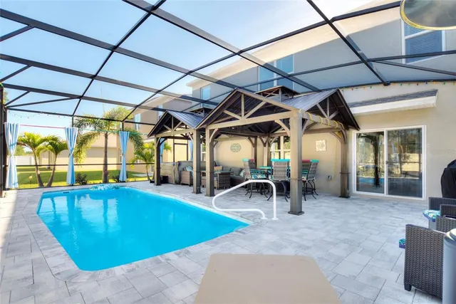 a view of a swimming pool with a patio and a tub