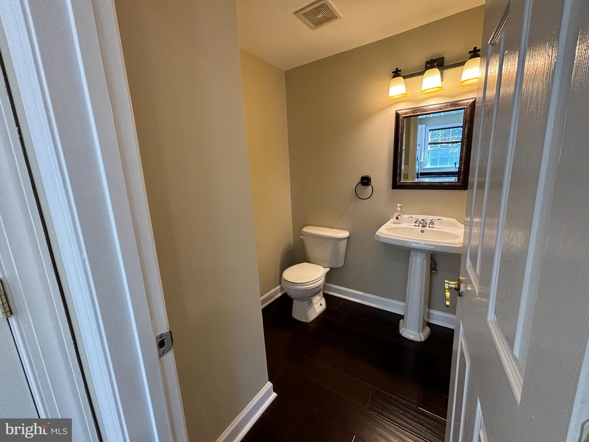 15656 Avocet Loop Woodbridge, VA 22191 - Photo 10 of 28 a bathroom with a toilet a sink and mirror