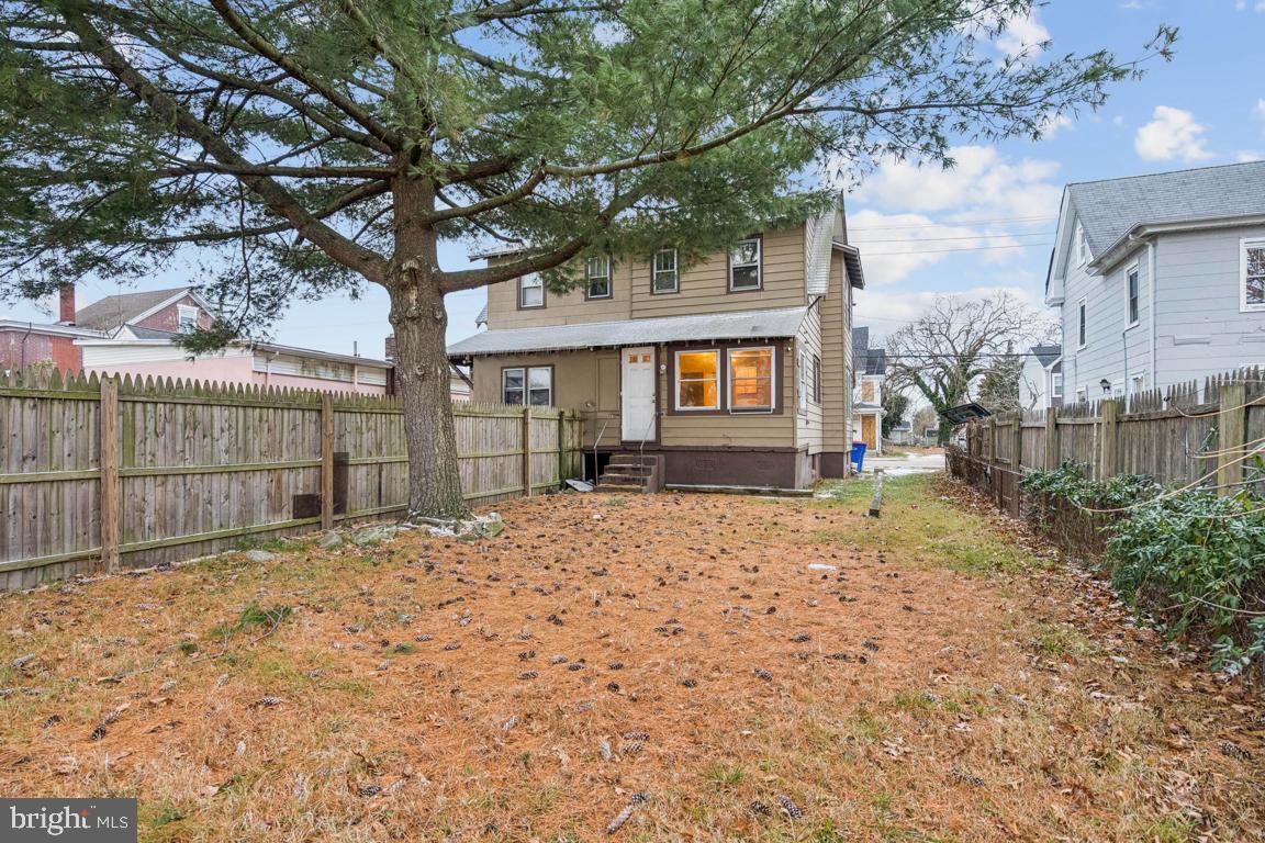 709 Buck Street Millville, NJ 08332 - Photo 18 of 20 a backyard of a house with wooden fence and large trees