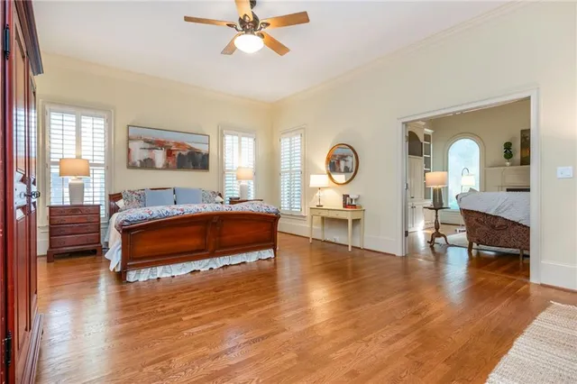 a dining room with wooden floor a chandelier a glass table and chairs