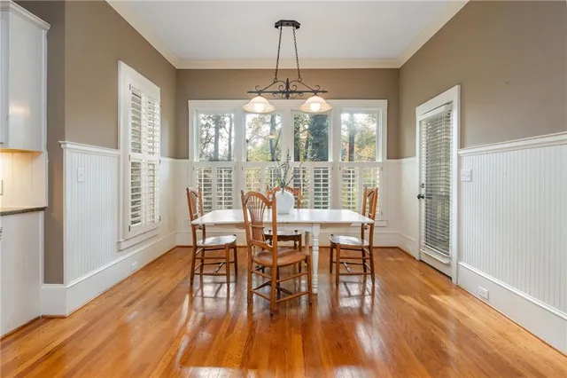 a view of a patio with table and chairs and potted plants with wooden floor and fence
