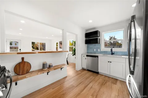 a kitchen with a sink a refrigerator and cabinets