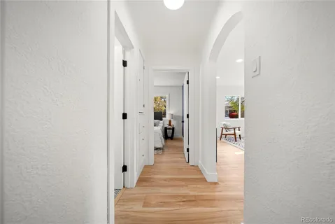 a view of a hallway with wooden floor and a living room