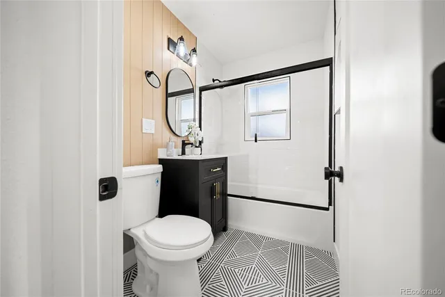 a bathroom with a toilet a sink and mirror