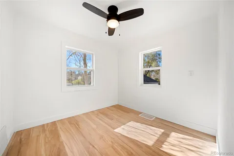 a view of empty room with wooden floor