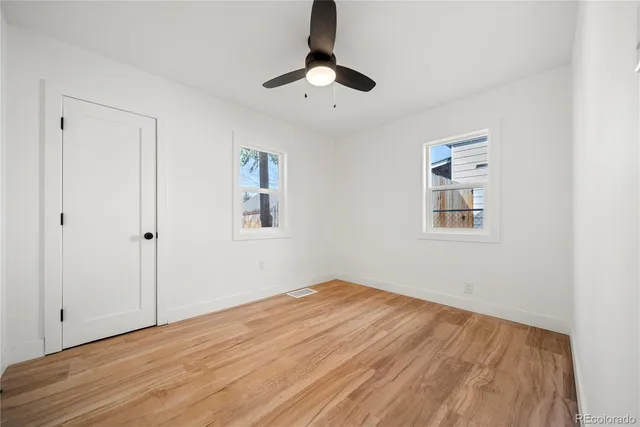 a view of empty room with wooden floor