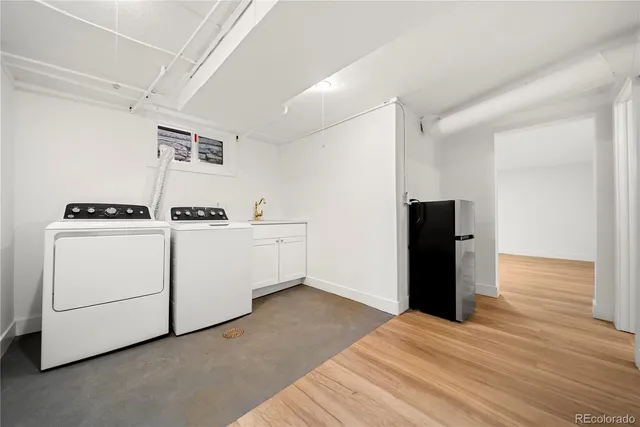 a view of kitchen with refrigerator and white cabinets