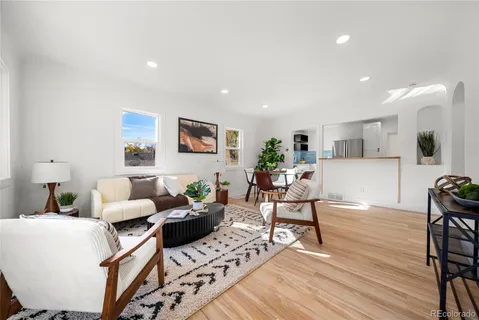 a living room with furniture and a wooden floor