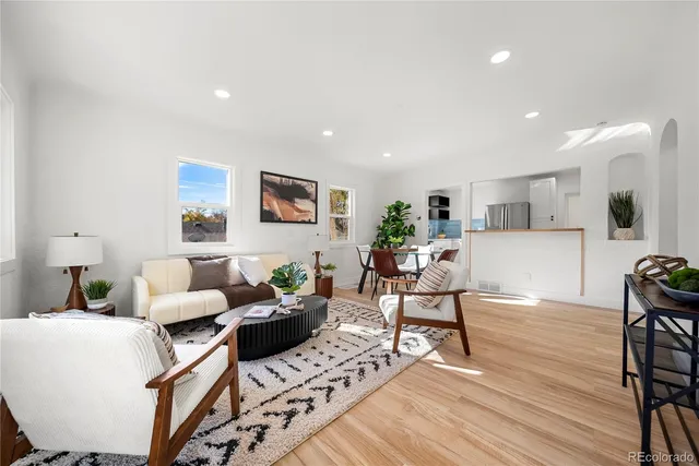 a living room with furniture and a wooden floor