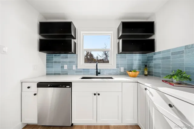 a kitchen with stainless steel appliances a sink dishwasher stove and white cabinets
