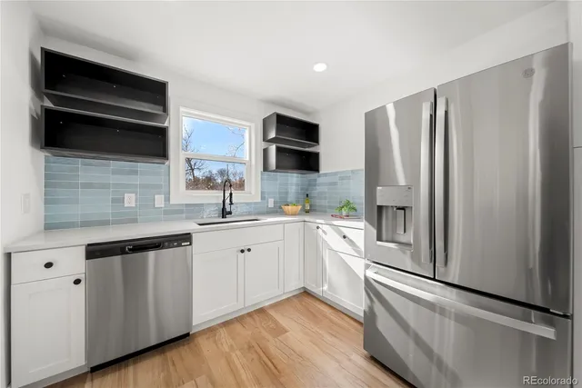 a kitchen with stainless steel appliances a refrigerator sink and microwave