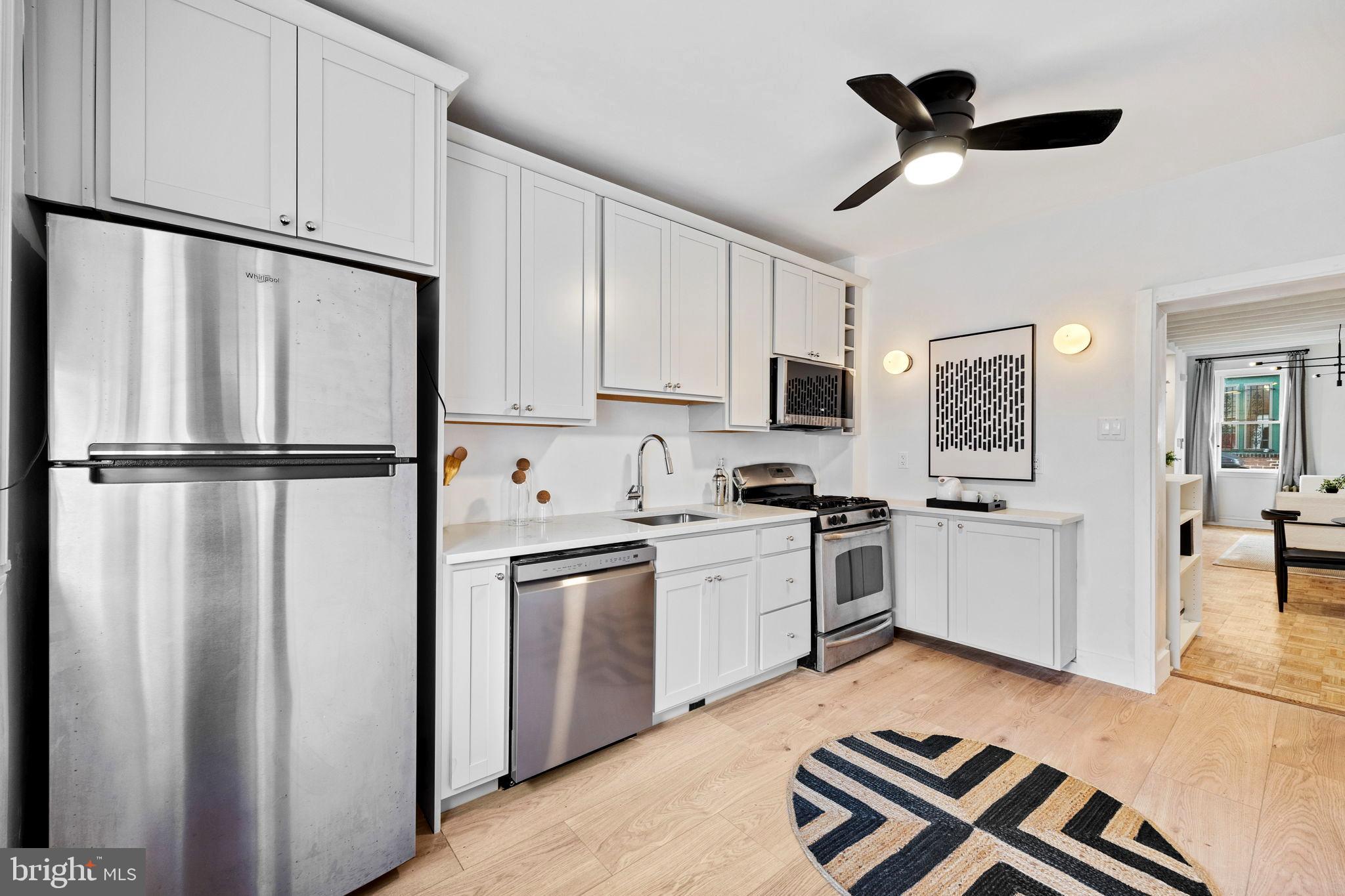 3138 Miller Street Philadelphia, PA 19134 - Photo 14 of 30 a kitchen with stainless steel appliances granite countertop a refrigerator a sink a stove and white cabinets