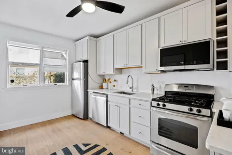 a kitchen with stainless steel appliances granite countertop a stove a microwave and a white cabinets