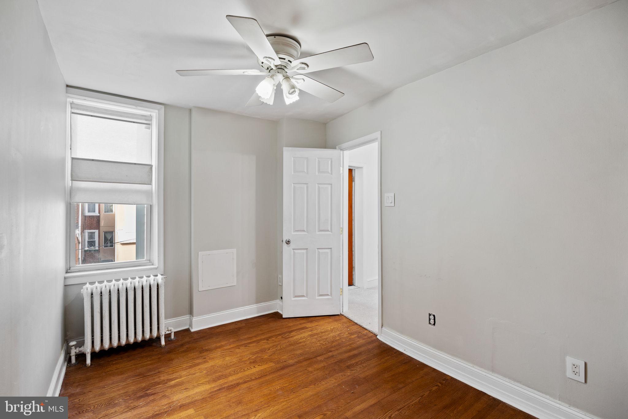 3138 Miller Street Philadelphia, PA 19134 - Photo 20 of 30 an empty room with wooden floor chandelier fan and windows