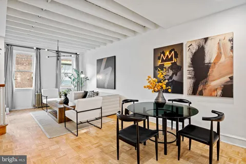 a living room with furniture and paintings on the wall