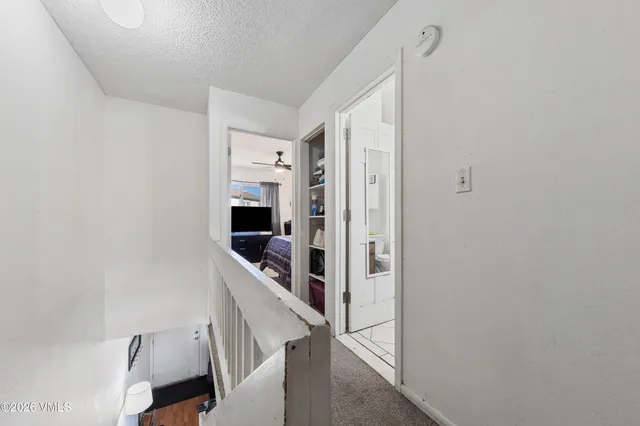 a hallway with white walls and stairs