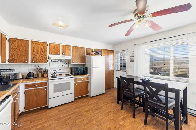 a kitchen with a table chairs refrigerator and cabinets